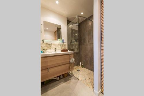 een badkamer met een wastafel en een douche bij Proche mer, plage et commerces à 500m in La Bernerie-en-Retz