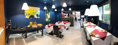 فيلا ريجينا في ريفا ديل غاردا: غرفة طعام بها طاولات وكراسي وجدار أزرق