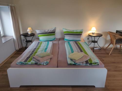 duas camas num quarto com duas mesas e duas lâmpadas em Eiderhufe em Holtsee