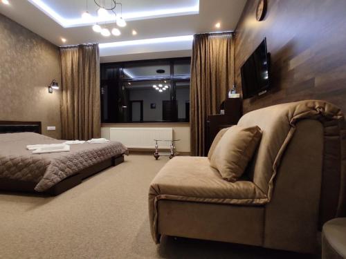 a bedroom with a bed and a couch and a television at Levanevsky Hotel in Odesa