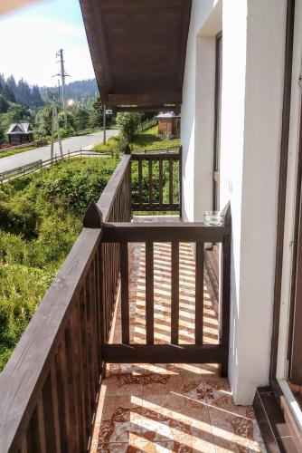 a balcony with a wooden railing and a view of a street at Затишний котедж "Хатинка" in Yablunytsya
