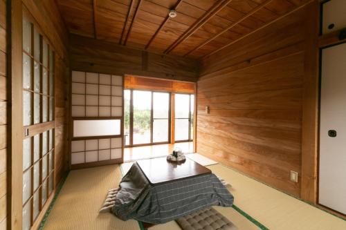 Kumage-gun - House - Vacation STAY 89468 في Yudomari: غرفة يابانية مع جدران خشبية وطاولة