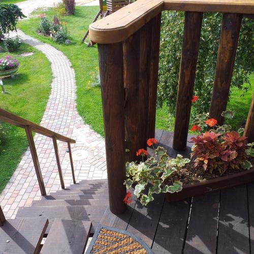 a wooden deck with a bench and flowers on it at Lielās spāres in Pāvilosta