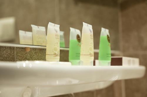 a shelf with green and white toothbrushes at Sela Hotel فندق صلة in Medina