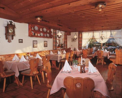 un restaurante con mesas y sillas y un reloj en la pared en Gasthof Hotel Reif en Königstein in der Oberpfalz