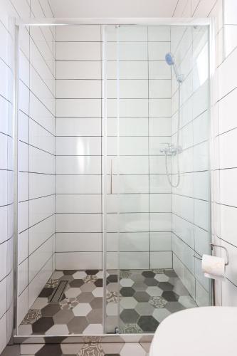 a bathroom with a shower with a glass door at 1oak rentals in Vir