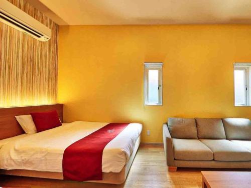 a bedroom with a bed and a couch at Kunigami-gun - Hotel - Vacation STAY 89678 in Inbu