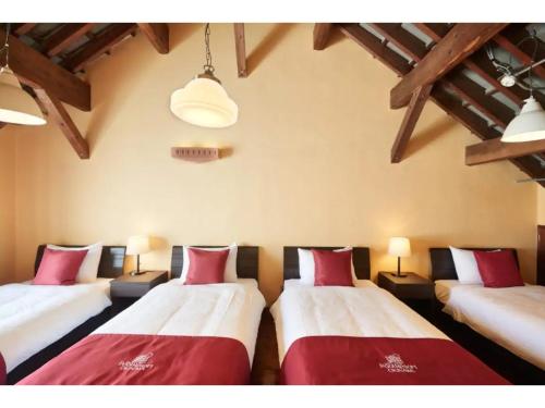 a room with three beds with red and white pillows at Kunigami-gun - Hotel - Vacation STAY 89682 in Inbu
