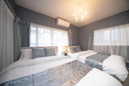 a bedroom with two beds and a chandelier at Grace Yotsugi - Vacation STAY 89021 in Tokyo