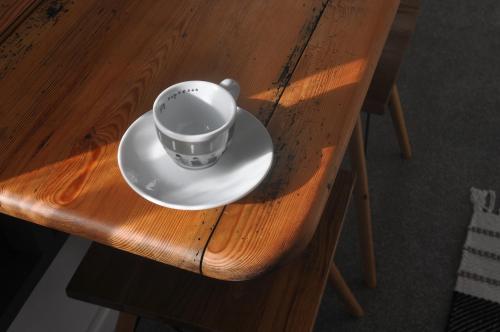 a cup on a plate on a wooden table at Bridge Street Apartments. Boutique Style Luxury, in the heart of Taunton. in Taunton