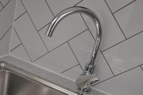 a kitchen sink with a chrome kitchen faucet at Bridge Street Apartments. Boutique Style Luxury, in the heart of Taunton. in Taunton