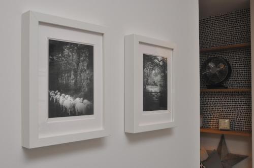 two white frames on a wall with a clock at Bridge Street Apartments. Boutique Style Luxury, in the heart of Taunton. in Taunton