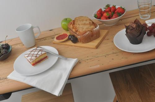 a table with plates of food and a cake and fruit at Bridge Street Apartments. Boutique Style Luxury, in the heart of Taunton. in Taunton