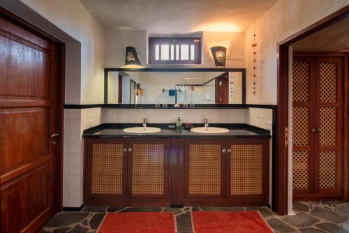 Un baño con dos lavabos y un espejo. en El Inti 2, en Tinajo