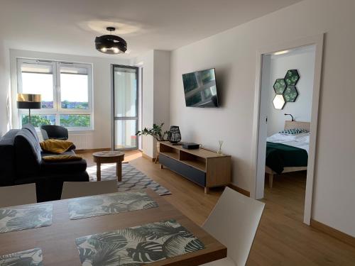 ein Wohnzimmer mit einem Zimmer mit einem Bett und einem Sofa in der Unterkunft Apartament Szmaragdowy Platan in Kołobrzeg