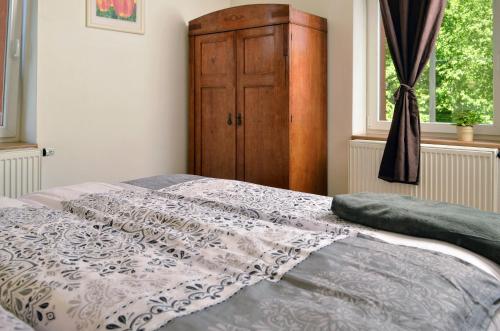 a bedroom with a bed with a dresser and a window at Apartmány Irisis in Chvaleč