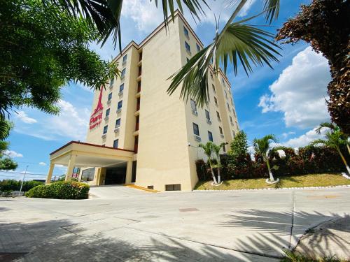 a hotel building with palm trees in the foreground at Paris FC Express in Poza Rica de Hidalgo