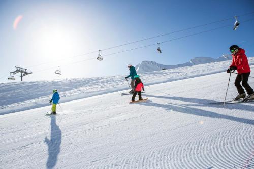 a group of people skiing on a ski lift at Hotel Garni Hubertushof in Fiss