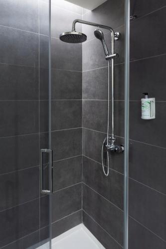a shower with a glass door and a shower head at B&B HOTEL Lisboa Aeroporto in Lisbon