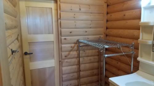 Zimmer mit einer Holzwand, einer Tür und einem Regal in der Unterkunft Maniwa - Cottage - Vacation STAY 90022 in Maniwa