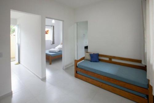 a bedroom with a bed and a room with two beds at Recanto do Camargo in Ubatuba