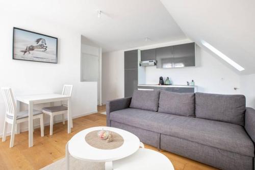 un salon avec un canapé et une table dans l'établissement GRAND CONFORT, Appartement Osny, à Osny