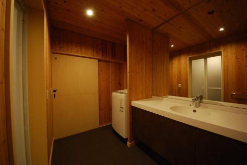 a bathroom with a sink and a mirror and a door at Cominka Hotel Shiki no Ie - Vacation STAY 89847 in Mitake