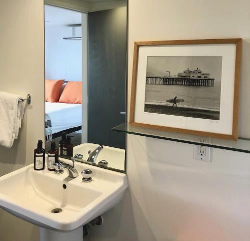 un baño con lavabo y una foto de un muelle en The M Malibu, en Malibú