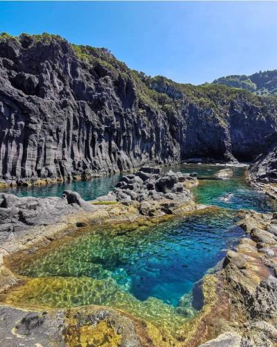 a pool of blue water in a rocky canyon at Casa da Eira Velha in Fajã do Ouvidor