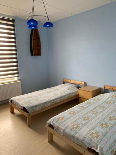 two beds in a room with blue walls and blue lights at Zenitude in Jumet