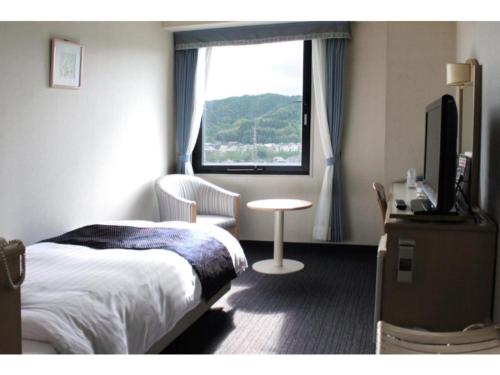 una camera d'albergo con letto e finestra di Hotel Verfort Hyuga - Vacation STAY 88276 a Hyuga