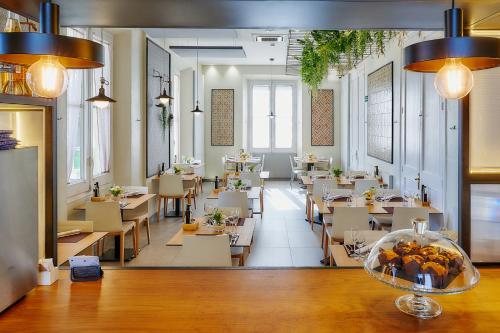 a restaurant with tables and chairs and a cafeteria at Hotel Arrey Alella in Alella