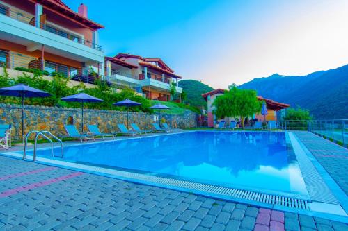a swimming pool at a hotel with chairs and umbrellas at Αlissachne Suites in Limniónas