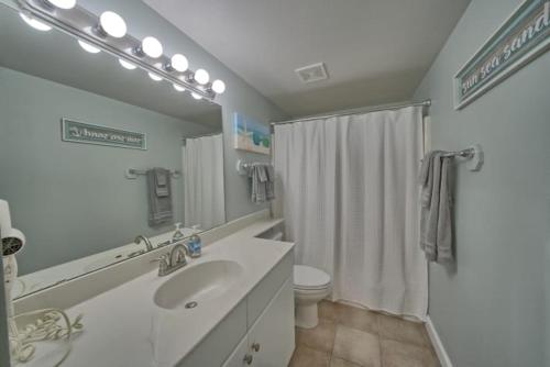 a bathroom with a sink and a toilet and a shower at Deluxe Beachfront Studio, Shores of Panama New and Renovated in Panama City Beach