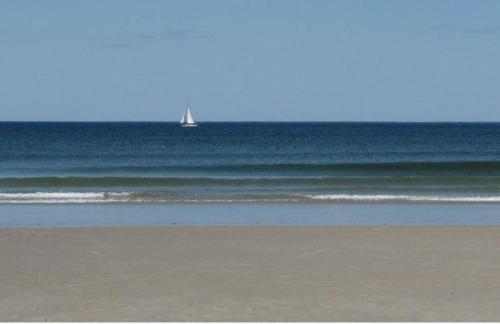 a sail boat in the ocean on a beach at Footbridge North Hotel in Wells
