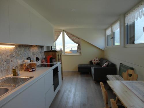 a kitchen and living room with a table and a couch at Appartamento Riscone Nuvola di Plan in Brunico