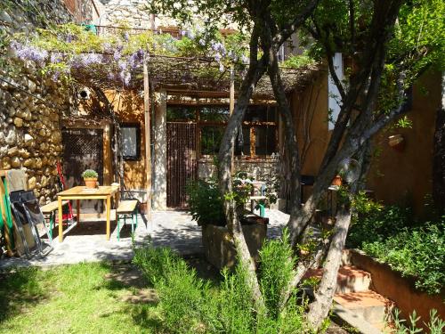 um jardim com mesa, cadeiras e árvores em Les Magranes Bed & Breakfast em Argelaguer