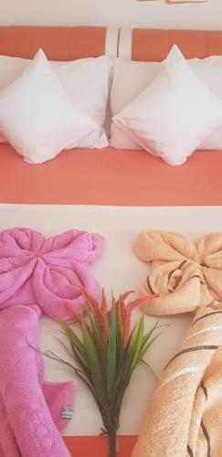 two pictures of a bed with towels on it at Apartmani Niksic in Herceg-Novi