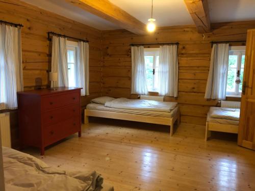 a bedroom with two beds in a log cabin at Roubenka Bratrouchov in Jablonec nad Jizerou