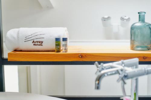 a bathroom counter with a towel and a bottle of alcohol at Hotel Arrey Alella in Alella