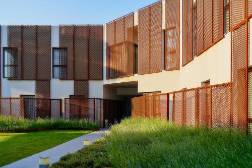 a building with a fence next to a grass field at Hotel Arrey Alella in Alella