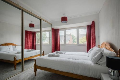 1 Schlafzimmer mit 2 Betten und einem großen Spiegel in der Unterkunft Hullidays - The Auckland House University Quarter in Hull