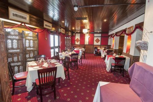 uma sala de jantar com mesas e cadeiras num restaurante em Roebuck Inn em Stevenage