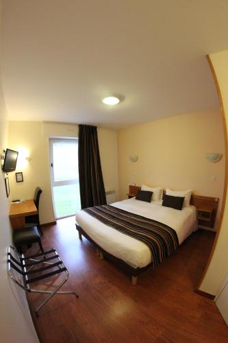 a hotel room with a large bed and a window at Auberge De Bourgogne in Tonnerre