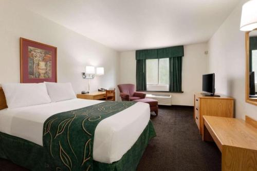 a hotel room with a large bed and a television at Travelodge by Wyndham Hermiston in Hermiston
