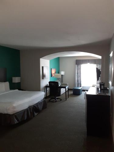 a hotel room with a bed and a desk at Baymont by Wyndham Andrews TX in Andrews