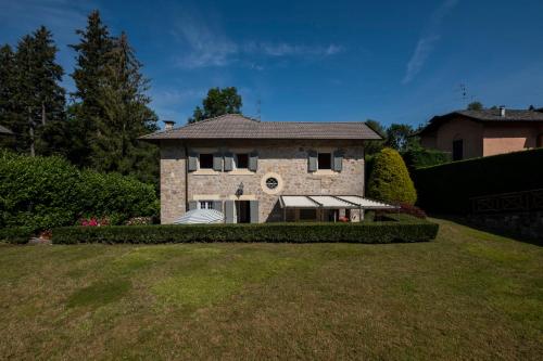 a large stone house on a grassy field at Contessa Pace - Luxury flat in Selvino