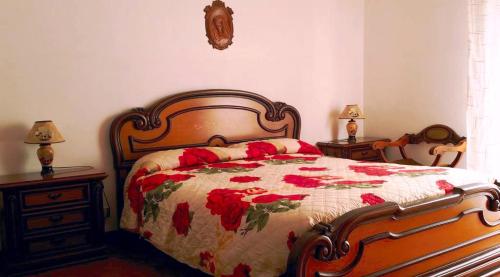 a bedroom with a bed with a red floral bedspread at B&B da Francesco in Modica