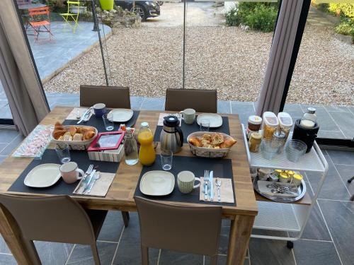 a wooden table with plates and food on it at Les Rives du Cher - Chambres d'hôtes in Montrichard