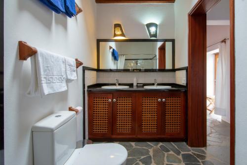 a bathroom with a toilet and a sink and a mirror at El Inti 1 in Tinajo